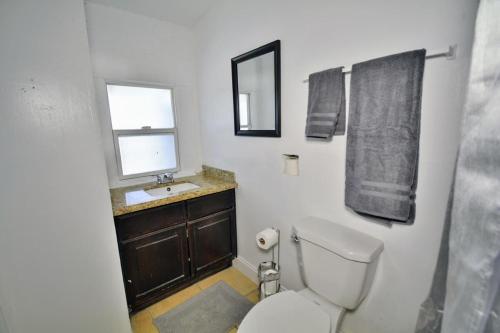 a bathroom with a toilet and a sink and a mirror at Entire Home Near UTEP in El Paso