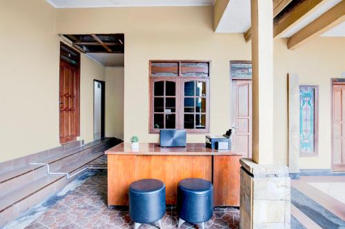 a lobby with a bar with blue stools at Hotel O Balikpapan near Taman Beruang Madu formerly Palm Cafe Inn in Balikpapan