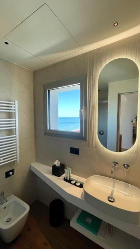 a bathroom with a sink and a mirror at Opera Suite Hotel Pesaro in Pesaro