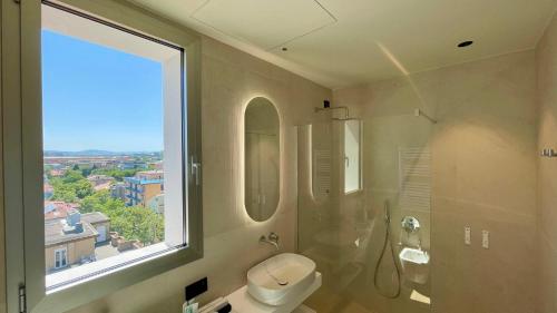 a bathroom with a toilet and a large window at Opera Suite Hotel Pesaro in Pesaro