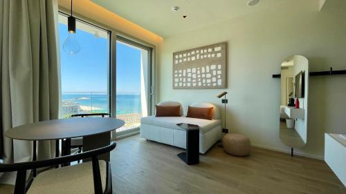 a living room with a table and a chair at Opera Suite Hotel Pesaro in Pesaro