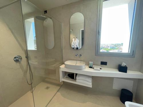 a bathroom with a sink and a shower at Opera Suite Hotel Pesaro in Pesaro