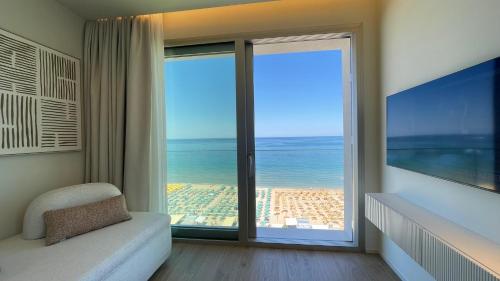 a room with a large window with a view of the ocean at Opera Suite Hotel Pesaro in Pesaro