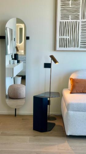 a room with a bed and a table and a mirror at Opera Suite Hotel Pesaro in Pesaro