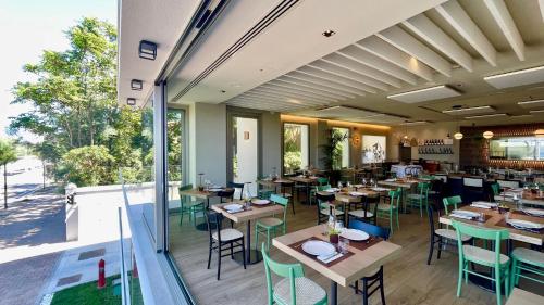 a restaurant with wooden tables and chairs and a large window at Opera Suite Hotel Pesaro in Pesaro