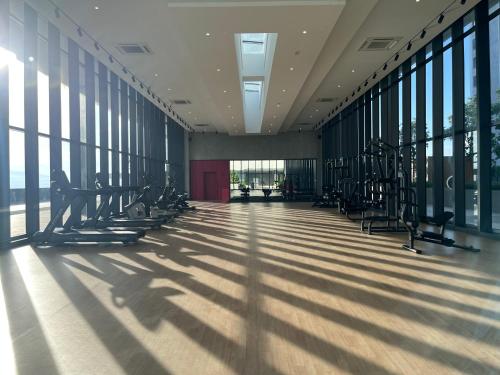 a gym with treadmills in a building with windows at Pool View Studio - 168 Park Selayang in Batu Caves