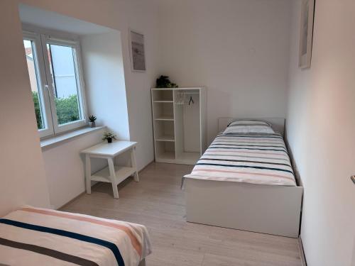 two beds in a small room with a window at Holiday home Omišalj in Omišalj