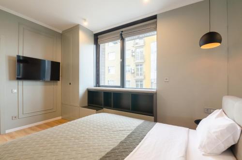 キーウにあるPetrovdom Apartments 17-183B in RC New York Concept House, 74 Antonovycha Streetのベッドと薄型テレビのある寝室