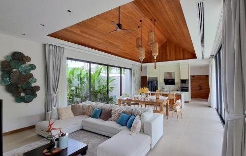 un salon avec un canapé blanc et une table dans l'établissement Bougainvillea Luxury Pool Villas, à Ban Pak Lak