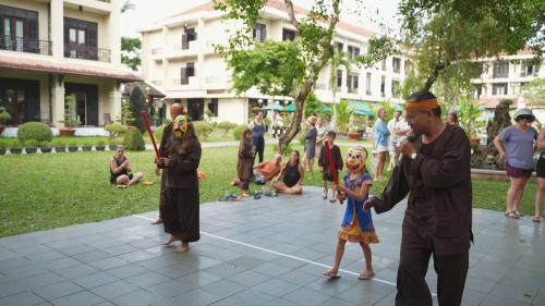 a man and a little girl standing in a park at HOI AN HISTORIC HOTEL in Hoi An