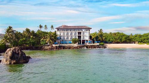 a large building on a island in the water at Garton's Cape in Ahangama
