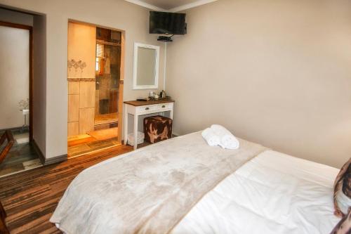 a bedroom with a white bed and a fireplace at Sewende Hemel in Kroonstad