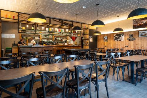 een restaurant met houten tafels en stoelen en een bar bij Hotel Castillan in La Grave