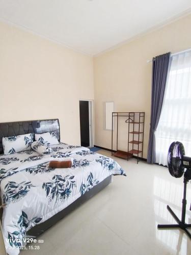 a bedroom with a bed and a window at Villa Putih O3 in Batu
