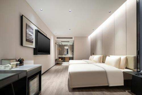 a hotel room with two beds and a television at Atour Hotel Xiamen Zhongshan Road General Temple in Xiamen