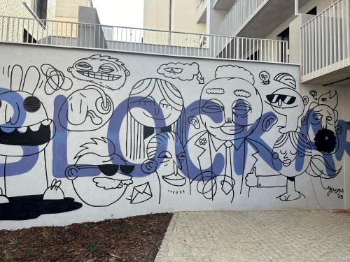a wall with a mural of faces on it at Haas Apartments Art with parking, bakery, coffea in Brno