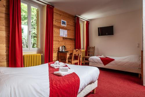 een hotelkamer met twee bedden met rode gordijnen bij Hotel Castillan in La Grave