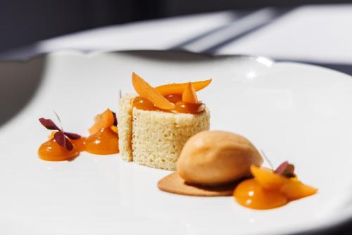 a piece of cake on a white plate with fruit at Château de Castel Novel Boutique Hôtel in Varetz