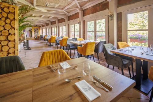 a dining room with tables and yellow chairs at Château de Castel Novel Boutique Hôtel in Varetz