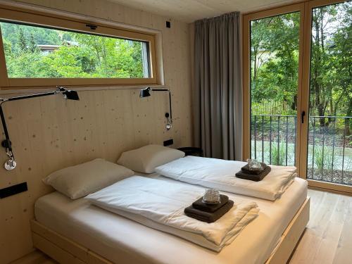 una camera da letto con un letto con due asciugamani sopra di Bio Design Appartements DAS GRAUE SCHAF - Kärnten Card im Sommer inklusive a Bad Kleinkirchheim