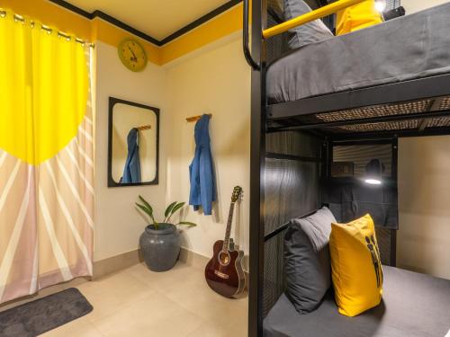 a bedroom with a bunk bed and a guitar at The Hosteller Nainital in Nainital