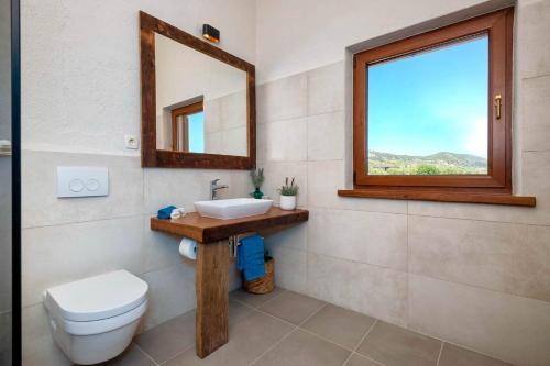 a bathroom with a sink and a toilet and a window at Astounding Hvar Villa 4 Bedrooms Villa Crystal Hvar 1 Mesmerizing Sea Views & Private Infinity Pool in Hvar