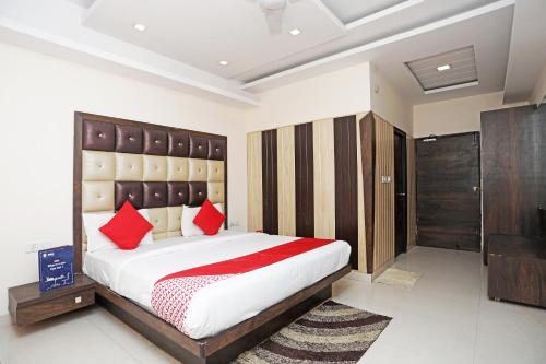 a bedroom with a large bed with red pillows at Super Hotel O Subhadra Residency in Meerut