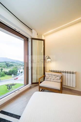 a bedroom with a bed and a large window at Avalón I By Silastur in Villaviciosa