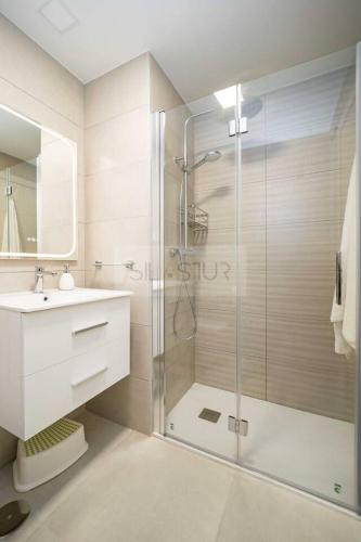 a bathroom with a glass shower and a sink at Avalón I By Silastur in Villaviciosa