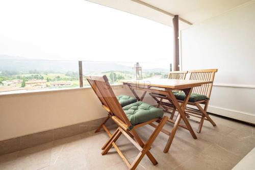 a dining room with a table and chairs and a large window at Avalón I By Silastur in Villaviciosa