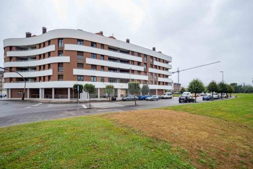a large building with a parking lot in front of it at Avalón I By Silastur in Villaviciosa