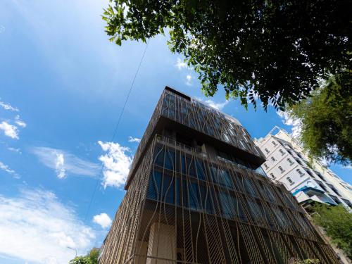 a tall building with glass windows on top of it at SOMA HOTEL Riverside in Phnom Penh