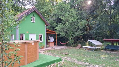 a green house with a hammock in a yard at Green House in Rijeka