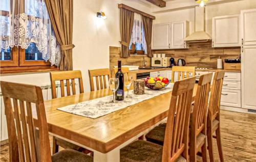 a kitchen with a wooden table with a bottle of wine at Amazing Home In Gospic With Wi-Fi in Gospić