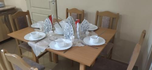 a dining room table with plates and dishes on it at KOÓS VENDÉGHÁZ in Uppony