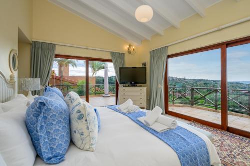 a bedroom with a large bed with a large window at San Lameer Villa 14317 - 4 Bedroom Deluxe - 8 pax - San Lameer Rental Agency in Southbroom