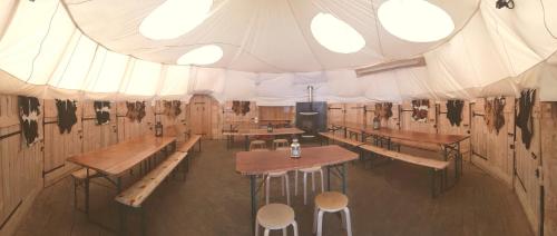 een tent met tafels en stoelen en een podium bij Village Tipi in La Féclaz