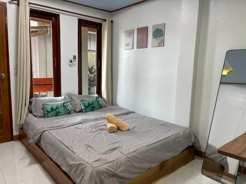 a bedroom with a bed with a teddy bear on it at ระเบียงเลเกาะลิบง โฮมสเตย์ in Ko Libong