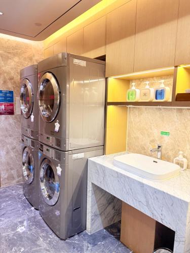 a bathroom with a washing machine and a sink at Novotel Xi'an The Bell Tower in Xi'an