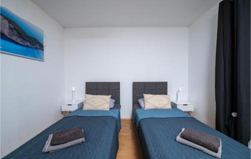 two beds in a room with blue sheets at Pet Friendly Apartment In Krsan in Kršan