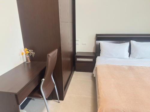 a bedroom with a desk and a bed and a chair at Jin Dun Yuan in Jinning