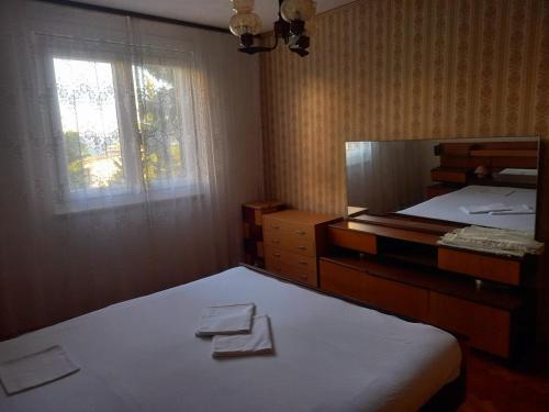 a bedroom with two beds and a mirror and a window at Largo in Crikvenica
