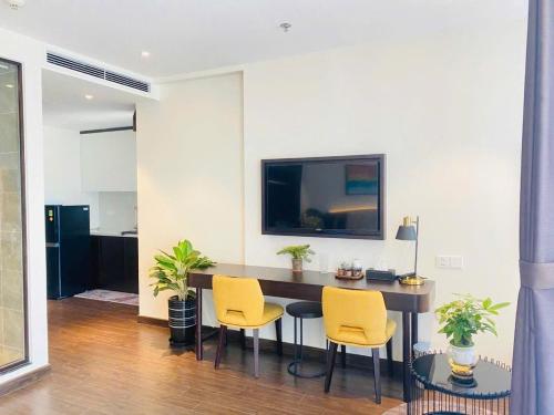 une salle à manger avec une table et deux chaises jaunes dans l'établissement The Sapphire residence, à Hạ Long