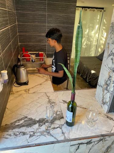 a man in a kitchen with a plant in a vase at private loft, comfortable, equipped, we invoice, in Torreón