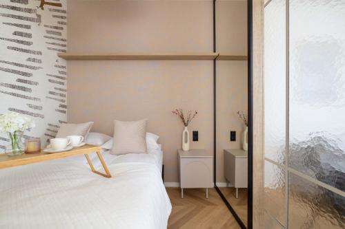 a small bedroom with a bed and a table at Elegant Studios in Katowice with Gym, Sauna & Cinema by Noclegi Renters in Katowice