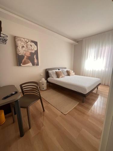 a bedroom with a bed and a table and a chair at Domus Eterea in Marsala