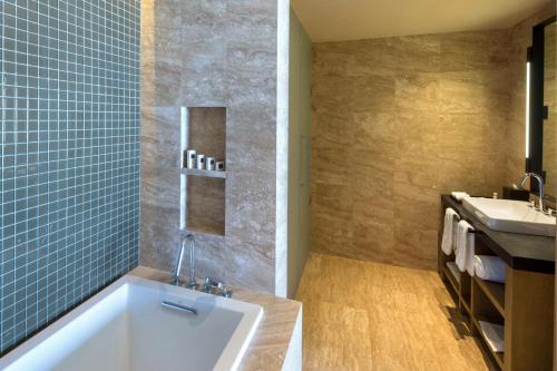 a bathroom with a tub and a sink at JW Marriott Los Cabos Beach Resort & Spa in San José del Cabo