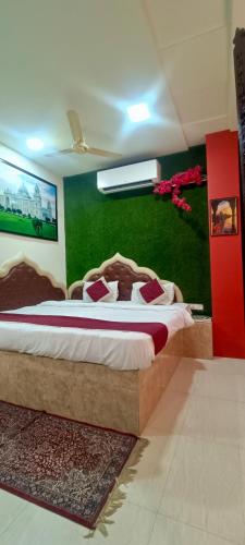 a bedroom with a large bed with a green wall at The Hideout Agra - Garden Homestay near Taj in Agra