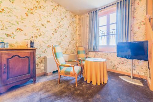 a room with a table and two chairs and a tv at Château de Castel Novel Boutique Hôtel in Varetz