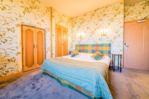a bedroom with a bed with floral wallpaper at Château de Castel Novel Boutique Hôtel in Varetz